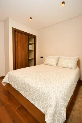 a bedroom with a large white bed with wooden floors at Atelier Aedes - Studio 1 in Maarif