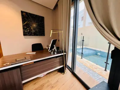 an office with a desk with a computer and a pool at Villa Bahia Golf beach - Bouznika in Casablanca