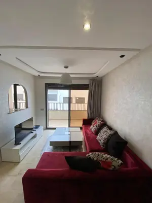 a living room with a red couch and a tv at 1 bed with balcony near CFC in Casablanca