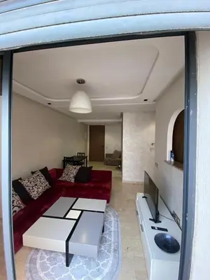 a living room with a red couch and a tv at 1 bed with balcony near CFC in Casablanca