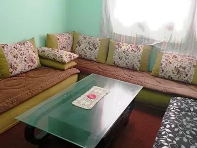 a living room with a couch and a table at espace chaleureux in Aïn ej Jmel