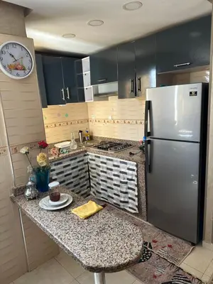 a kitchen with a stainless steel refrigerator and a counter at Ahmed 205 in Temara