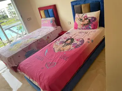 two twin beds in a room with pink sheets at Casabay SidiRahal Appartement à louer in Sidi Rahal