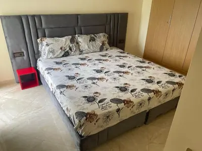 a bed in a room with a bedspread with flowers at Casabay SidiRahal Appartement à louer in Sidi Rahal