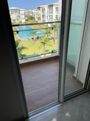an open door to a balcony with a view of the ocean at Casabay SidiRahal Appartement à louer in Sidi Rahal