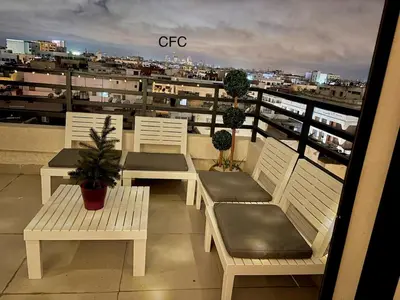 a balcony with white benches and a view of a city at nouveau penthouse en plein centre de casa in Casablanca