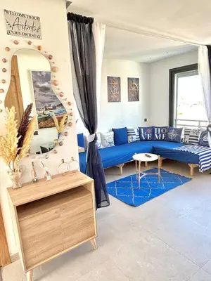 a living room with a blue couch and a mirror at nouveau penthouse en plein centre de casa in Casablanca