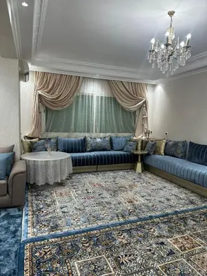 a living room with a blue couch and a table at McDonalds Apartment 2 Mars in Casablanca