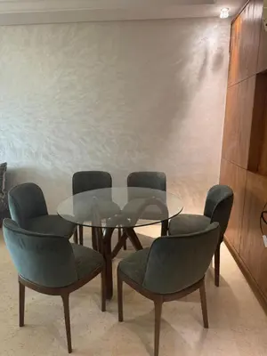 a dining room with a glass table and four chairs at Appartement Sara in Mohammedia