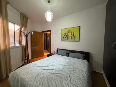 a bedroom with a bed and a lamp and a window at Housse moderne Versailles in Rabat