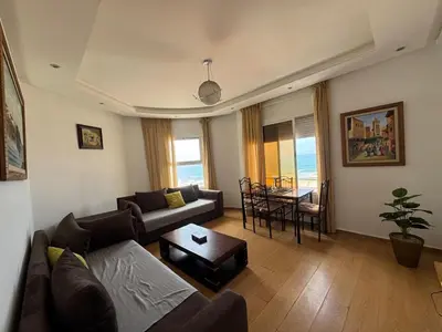 a living room with a couch and a table at Housse moderne Versailles in Rabat
