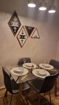 a table with chairs and plates and glasses on it at Cosy Stay 15min from Casablanca Airport, in Berrechid in Berrechid