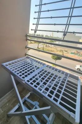a metal bench sitting in front of a window at Cosy Stay 15min from Casablanca Airport, in Berrechid in Berrechid