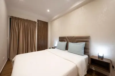 a bedroom with a large white bed with blue pillows at Appartement Cosy Casablanca in Casablanca
