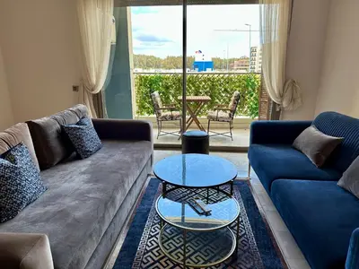 a living room with a couch and a table at AeroRelax, free Parking, WI-FI in Nouaseur