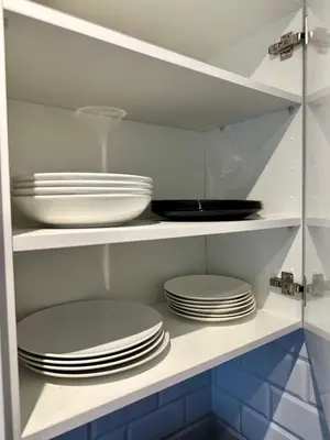 a kitchen with white plates and bowls on shelves at AeroRelax, free Parking, WI-FI in Nouaseur