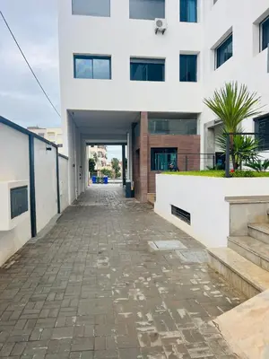 an empty street in front of a white building at W&M LUXOR residence TEMARA in Temara