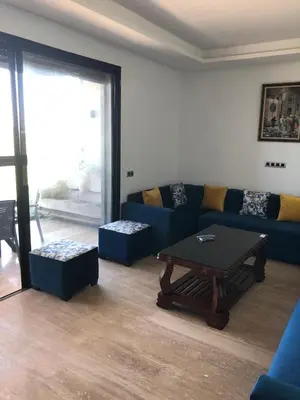 a living room with a blue couch and a table at Appartement Sidi Rahal Oceanic in Sidi Rahal