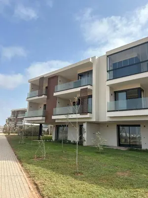 an apartment building with a lawn in front of it at Appartement Sidi Rahal Oceanic in Sidi Rahal
