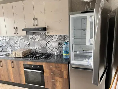 a kitchen with a stove top oven next to a refrigerator at Family in Dar Bouazza