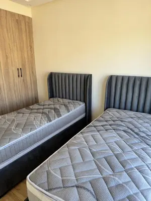 two beds sitting next to each other in a room at Family in Dar Bouazza