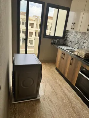 a kitchen with a refrigerator and a counter in a room at Family in Dar Bouazza