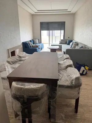 a living room with a table and a couch at Family in Dar Bouazza