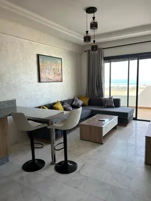 a living room with a couch and a table at Ocean park zenata in Aïn Harrouda