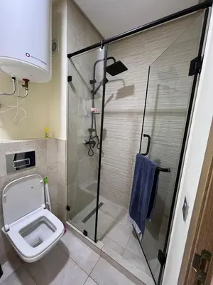 a bathroom with a toilet and a glass shower at Ocean park zenata in Aïn Harrouda