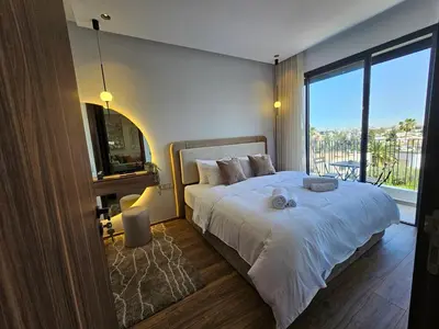a bedroom with a large bed and a large window at Central Luxurious & Great Location Ultra Fast Wi-Fi In The Heart Of Casablanca Oasis Disrict With A City View in Casablanca