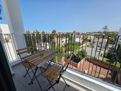 a table and chairs on a balcony with a view at Central Luxurious & Great Location Ultra Fast Wi-Fi In The Heart Of Casablanca Oasis Disrict With A City View in Casablanca