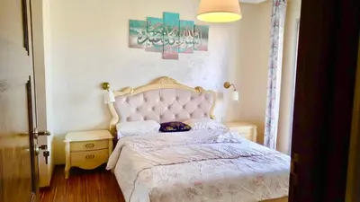 a bedroom with a bed with a white bedspread at Bel appartement in Mohammedia