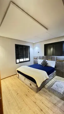 a bedroom with a large bed with blue sheets and a window at Zahira New Luxury Near The Beach - Entire Apartment in Casablanca