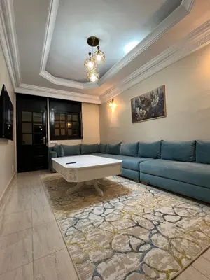 a living room with a blue couch and a table at Longement moderne à Rabat in Rabat