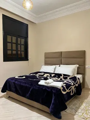 a bedroom with a large bed with a blue blanket at Longement moderne à Rabat in Rabat
