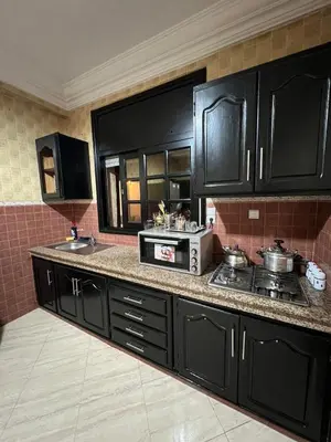 a kitchen with black cabinets and a stove top oven at Longement moderne à Rabat in Rabat