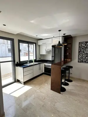 a kitchen with white cabinets and a table with chairs at chic escape in Casablanca