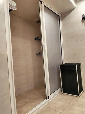 a walk in shower with a sliding glass door at Charming apartment agdal rabat in Rabat