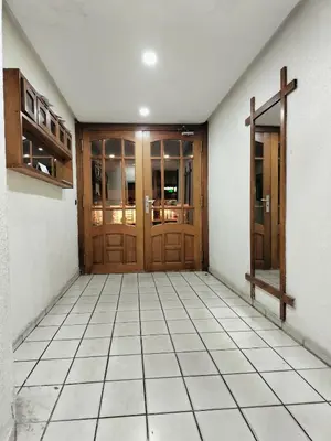 a hallway with two wooden doors and a tile floor at Charming apartment agdal rabat in Rabat
