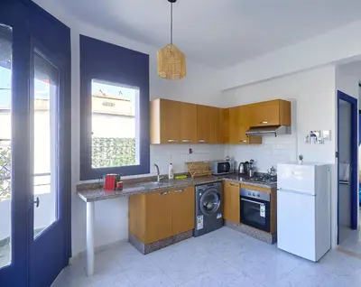 a kitchen with wooden cabinets and a washer and dryer at Suite BD ANFA - Queen Bed & Private Balcony in Casablanca
