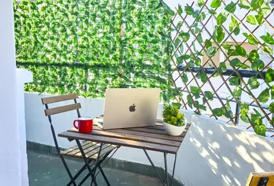 a laptop sitting on a table on a chair on a balcony at Suite BD ANFA - Queen Bed & Private Balcony in Casablanca