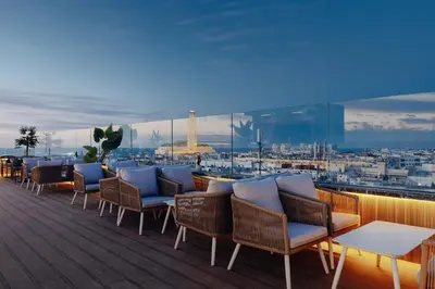 a rooftop deck with chairs and a view of a city at Exe Casablanca in Casablanca