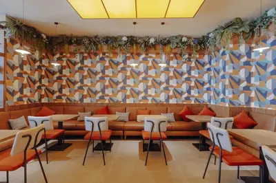 a restaurant with a couch and tables and chairs at Exe Casablanca in Casablanca