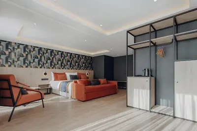 a bedroom with a bed and a couch and a chair at Exe Casablanca in Casablanca