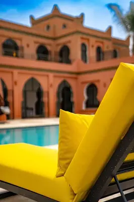 a yellow chair sitting next to a swimming pool at Domaine Terra Cotta - Villa de luxe avec piscine sans vis-à-vis in Souk el Had