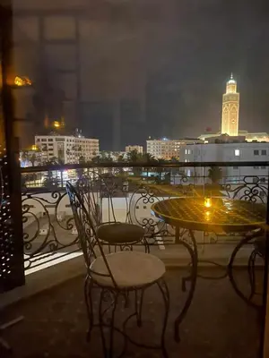 a table and chairs on a balcony at night at Résidence Val d'Anfa in Casablanca