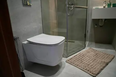 a bathroom with a toilet and a glass shower at Ain Diab Ocean Breeze & Parking in Casablanca