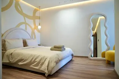 a bedroom with a large bed and a yellow chair at Ain Diab Sunrise Nest & Parking in Casablanca