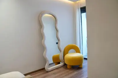 a room with a yellow chair and a mirror at Ain Diab Sunrise Nest & Parking in Casablanca