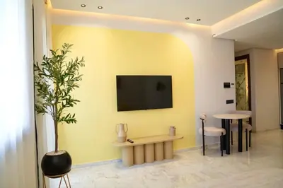 a living room with a tv on a yellow wall at Ain Diab Sunrise Nest & Parking in Casablanca